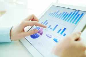 Pessoa segurando um tablet com gráficos